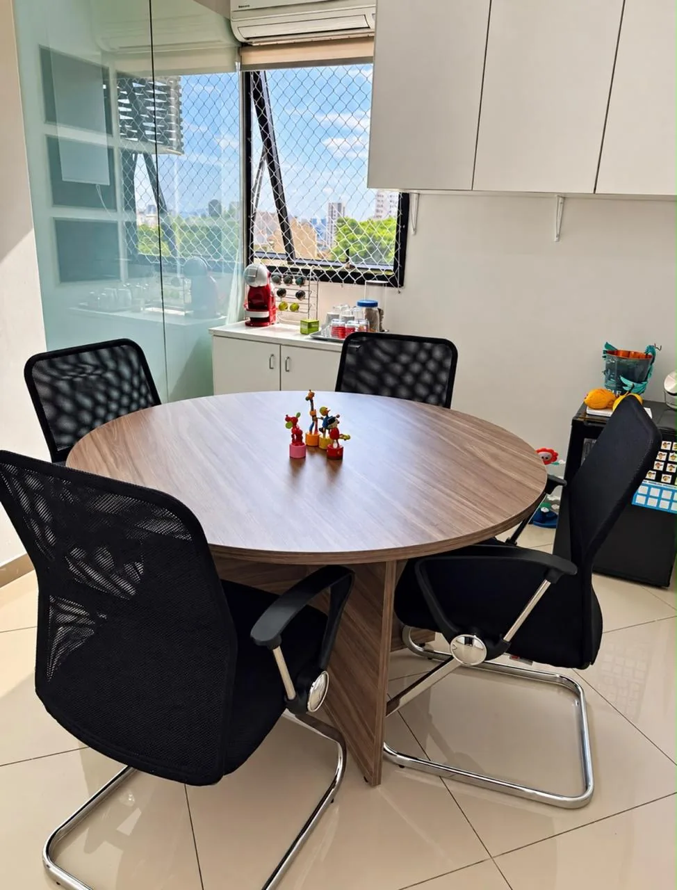 Sala de reunião com mesa, cadeiras e materiais organizados para conversas da equipe
